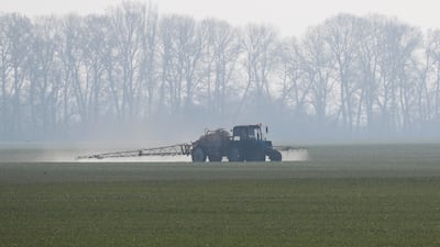 An agricultural worker drives a tractor on a wheat field near the village of Husachivkam, near Kyiv, in April 2020. Reuters