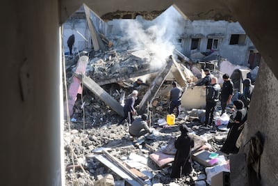 Palestinians inspect the rubble and debris at the site of Israeli air strikes the night before at Nuseirat refugee camp in the central Gaza Strip on March 23, 2025. AFP