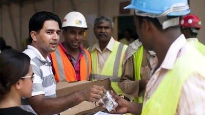 Shahid Zubair hands out water to laborers at a construction site this week. During summer it is incredibly important to stay hydrated, especially if one works outside. Lee Hoagland / The National