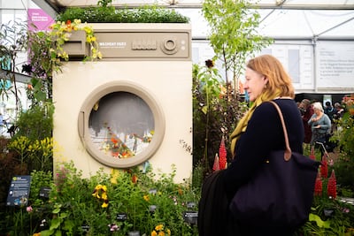 A person walks past a washing machine floral display. PA Wire