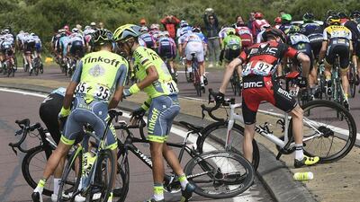 Croatia’s Robert Kiserlovski, left, gives his bicycle to Spain’s Alberto Contador, centre, after he crashed with Brent Bookwalter of the US, right, during the first stage of the Tour de France first stage of the Tour de France cycling race from Mont Saint-Michel to Utah Beach, France, Saturday, July 2, 2016. Jerome Prevost / Pool via AP
