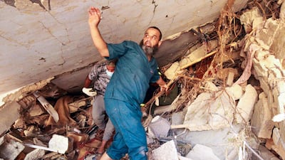 People search in the rubble of a building in a flash flood-damaged area in Derna. AFP