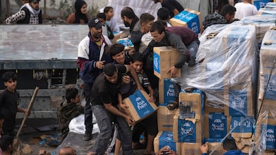 Palestinians take boxes from a humanitarian aid truck as it crossed into the Gaza Strip AP