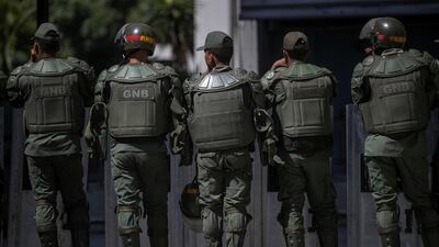 A dog rests behind National Bolivarian Guard (GNB) agents as they watch the surroundings of the National Assembly (NA), in Caracas, Venezuela, 15 May 2019. EPA