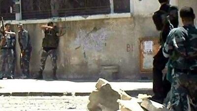 This image made from video released by the Syrian official news agency Sana purports to show Syrian troops fighting rebels in the Al Midan area in Damascus on Tuesday.