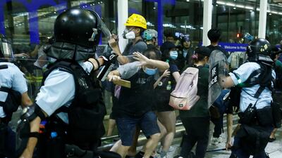 A police officer sprays pepper spray at anti-government protesters during clashes at the airport in Hong Kong. Reuters