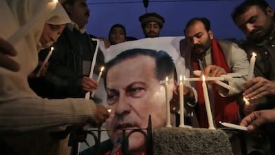 Pakistanis light candles to honour slain Punjab governor Salman Taseer, pictured on poster, in Peshawar in January. One of Taseer's bodyguards shot and killed him because he was enraged by his opposition to the country's blasphemy law.