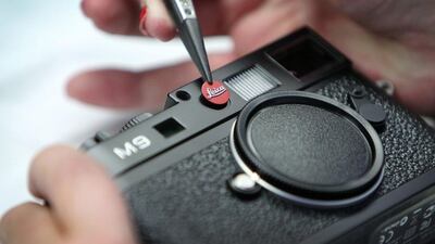 A mechanic fixes the Leica logo to an M9 camera at the production facility of Leica in Solms, western Germany. Daniel Roland / AFP