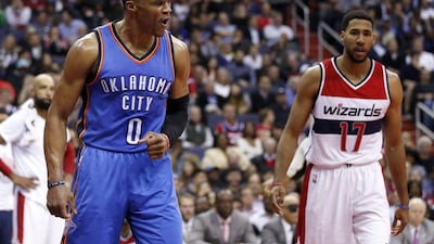 Russell Westbrook, left, reacts after a dunk, near Washington Wizards guard Garrett Temple. Alex Brandon / AP Photo