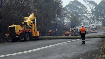Workers replacing utility poles following bushfires in the outskirts of Quaama in Australia's New South Wales state. AFP