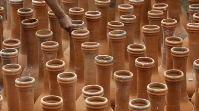 A Kashmiri boy arranges pottery before market opening on the outskirts of Srinagar. EPA