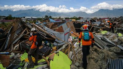 Members of an Indonesian search and rescue team walk amongst the debris in Petobo in Central Sulawesi. AFP