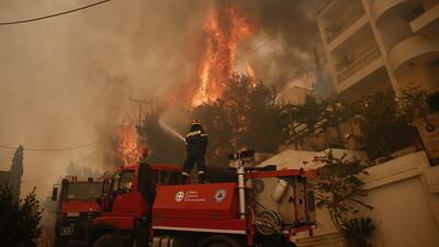 A fireman tries to extinguish flames during a wildfire in the suburb of Voula, south of Athens, Greece. EPA