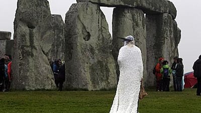 Gleu Sunpooja stands in front of Stonehenge as solstice revellers celebrate the arrival of the midsummer sunrise at the megalithic monument near Salisbury, England.
