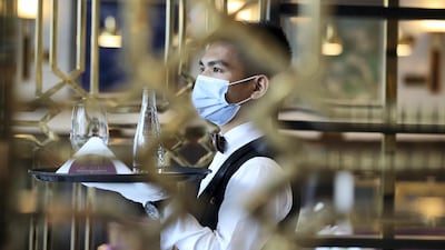 An employee brings drinks to customers at Cafe Society in Dubai. Chris Whiteoak / The National
