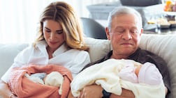 Queen Rania and King Abdullah cradling their twin granddaughters. Photo: Queen Rania / Instagram