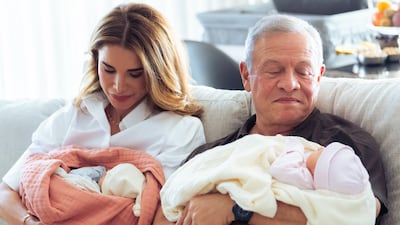 Queen Rania and King Abdullah cradling their twin granddaughters. Photo: Queen Rania / Instagram