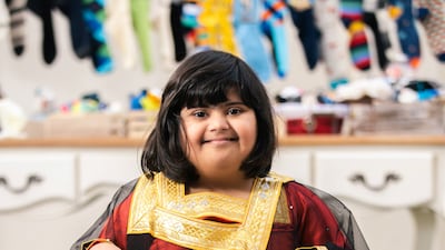 Latifa, 9, holds up her mum's certificate.