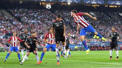 Saul Niguez of Atletico Madrid jumps for the ball with Robert Lewandowski of Bayern Munich. David Ramos / Getty Images