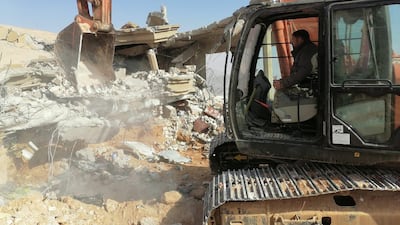 An excavator removes debris left after an air strike at headquarters of Kataib Hezbollah militia group in Qaim, Iraq. Reuters