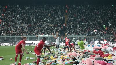 Players from Besiktas and Antalyaspor move toys to side of pitch after fans threw them down from stands at Vodafone Park in Istanbul on February 26, 2023, in support of children affected by the recent earthquakes in Turkey and Syria. Reuters