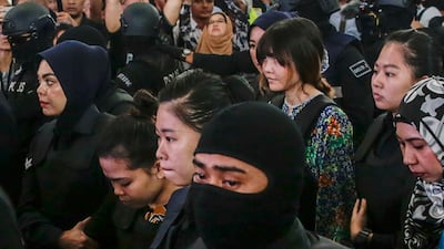 Indonesian Siti Aisyah (2L) and Vietnamese Doan Thi Huong (2R) are escorted as they revisit the scene of the attack at Kuala Lumpur International Airport in Sepang, Malaysia, on October 24, 2017. Fazry Ismail / EPA