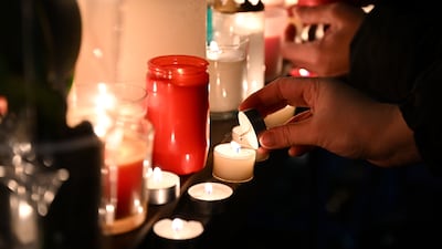 A mourner lights a candle in tribute to those killed. Italy and France have pledged their support to Switzerland after the fire. Getty Images