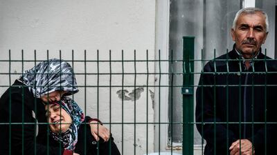 A mother, centre, of a victim cries as she waits for the body of her son at the forensic building in Ankara the day after a suicide car bomb ripped through a busy square. Ozan Kose / AFP