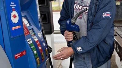 A customer fills up a vehicle with fuel at an Exxon Mobil gas station in Rockford, Illinois, US. Exxon Mobil is cutting its drilling budget to a 10-year low amid the price slump. Daniel Acker / Bloomberg
