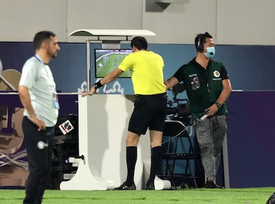 Referee Omar Mohamed Alali reverses his penalty decision. Chris Whiteoak / The National