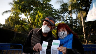 Israelis display their ‘Green Pass’, proof of vaccination or immunity against the coronavirus, at the entrance to a performance by singer Nurit Galron at Yarkon Park in Tel Aviv.