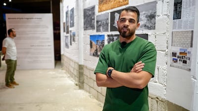 Syrian photojournalist Ghaith Alsayed stands in front of his photographs at the event. Ahmad Fallaha / The National