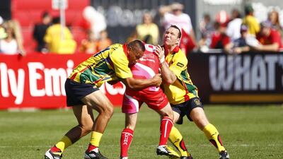 Apollo Perelini of CNCF Legends, left, tackles Jo Czerpak of Stefans BHF, centre, during the Dubai Rugby Sevens International Veterans match between CNCF Legends and Stefans BHF at The Sevens in Dubai on Friday. Jake Badger for The National