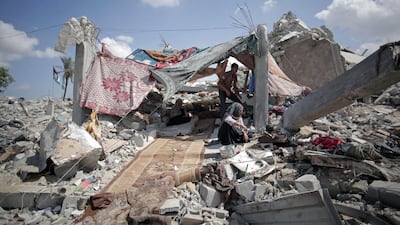 A Palestinian family shelters amid the rubble of their destroyed house in the town of Khan Younis in the southern Gaza Strip. The need for new homes is chronic and unrelenting. Khalil Hamra / AP