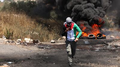 A Palestinian protester runs to seek cover from Israeli soldiers during clashes after a demonstration against Israel's plans to annex parts of the occupied West Bank in the village of Kufr Qaddum near the northern West Bank city of Nablus. EPA