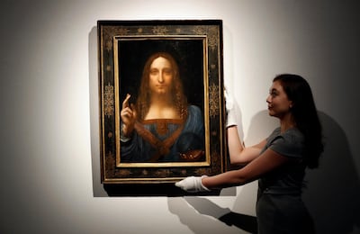An employee poses with Leonardo da Vinci's "Salvator Mundi" on display at Christie's auction rooms. (AP Photo/Kirsty Wigglesworth, File)