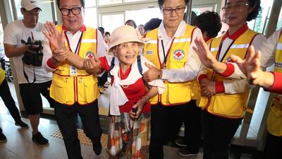 South Korean Lee Geum-seom, 92, second from left, is helped by Red Cross officials as she arrives to take part in family reunions with her North Korean family members at a hotel in Sokcho, South Korea. AP