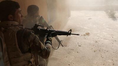 Iraqi soldiers search a house during clashes with ISIL fighters in Al-Qasar.