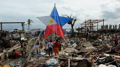 Philippines: Residents and survivors of Super Typhoon Haiyan decorate a giant lantern amongst the debris from destroyed houses in the coastal area of Tacloban, Leyte province. AFP Photo / Ted Alijibe