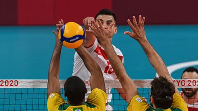 Tunisia's Wassim Ben Tara (C) spikes the ball in the men's preliminary round pool B volleyball match between Brazil and Tunisia during the Tokyo 2020 Olympic Games at Ariake Arena in Tokyo on July 24, 2021. (Photo by YURI CORTEZ / AFP)