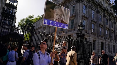 Protesters stand at the gates to Downing Street in London. AP