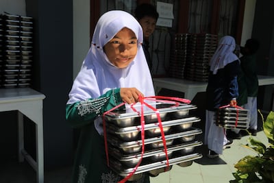 Indonesian students receive free meals at an elementary school in Banda Aceh on Thursday. School feeding programmes are powerful social investments. EPA