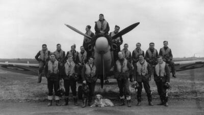 The pilots of a Second World War British fighter squadron crowded around a spitfire with their canine mascot in May 1941. Getty Images