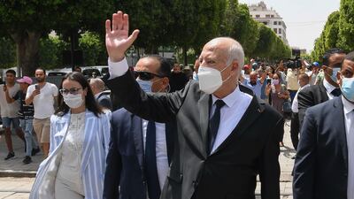 Tunisian President Kais Saied waves to bystanders in Tunis.
