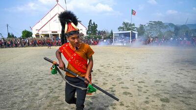 A Konyak tribesman with a gun dances at a community gathering in Longwa village