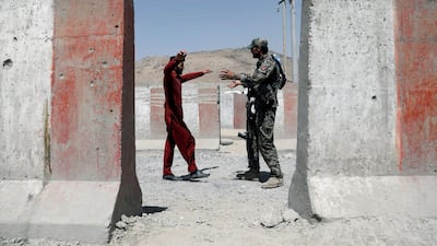 An Afghan soldier inspects a passenger at a checkpoint on the Ghazni-Kabul highway. Reuters