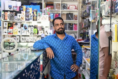 Abul Razzaque, owner of Sahal Mobile Phones, has been receiving several phones for repair, after the damages caused by rain in Fujairah. Khushnum Bhandari / The National