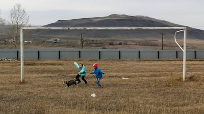 Children play with a puppy near a goalpost on a football pitch in the Siberian settlement of Novosyolovo, Krasnoyarsk region, Russia. Ilya Naymushin / Reuters