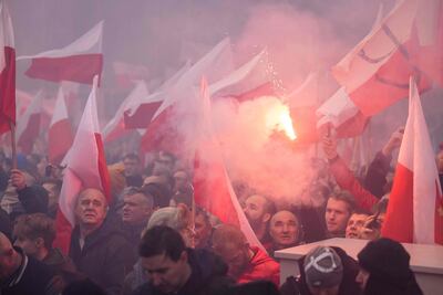 Participants burn flares and wave Polish flags as they take part in the country's Independence Day march. AFP