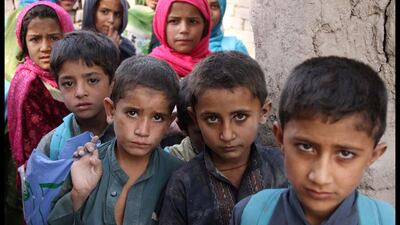 Class divide: Afghan children line up to go to their school near a refugee camp on the outskirts of Kabul, Afghanistan. S. Sabawoon / EPA